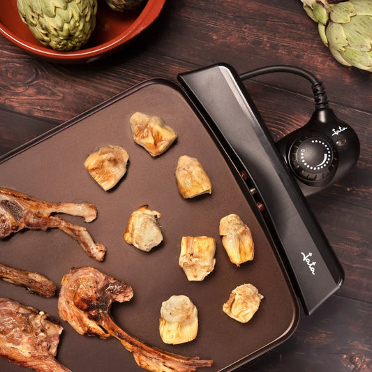 Detalle de la parrilla eléctrica Jata JEGR0550 Senses en uso, mostrando el control de temperatura y alimentos asados