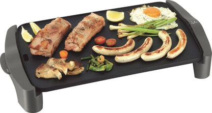 Parrilla eléctrica con carnes, salchichas, vegetales y huevo asados sobre la superficie.